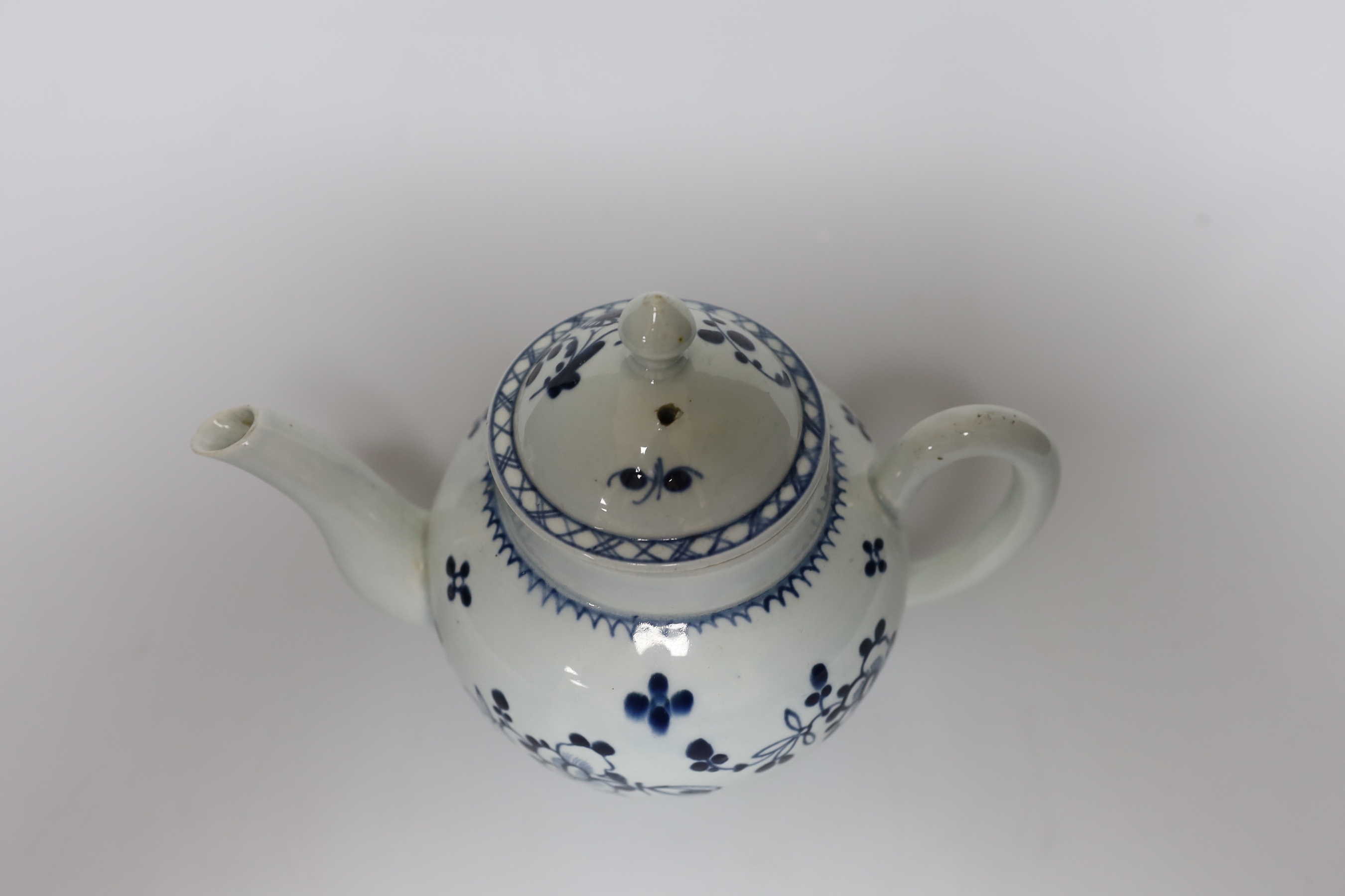 A Liverpool teapot and cover painted with flowers in underglaze blue, c.1775, 15cm tall